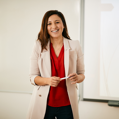 happy-female-teacher-standing-in-front-of-whiteboa-2024-12-13-22-03-49-utc.png